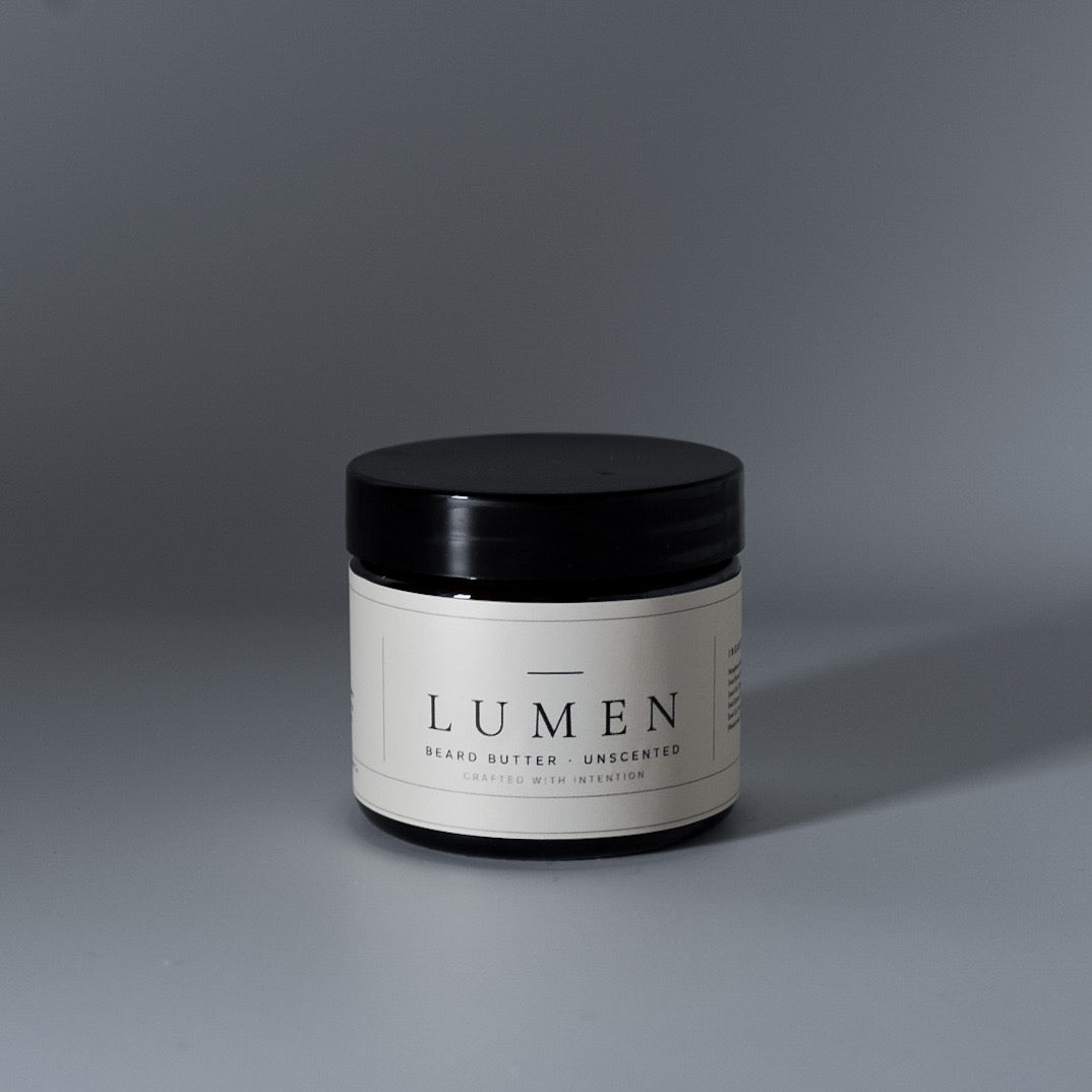 Close-up of LUMEN Unscented Beard Butter jar on a grey surface.